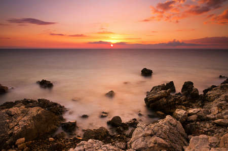 Beautiful colored sunset at the rocky coast of Croatiaの写真素材