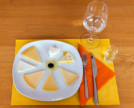 Variety of cheeses presented on a plate on a wooden table