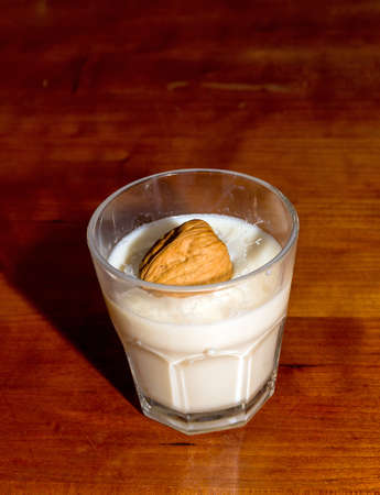 Walnut drops in a glass of milkの写真素材