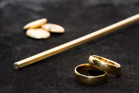 Concept of the process where a lump of gold is transformed into a pair of wedding ringsの写真素材