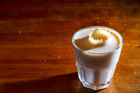 Drops of coffee splashing in a glass of milk, high speed