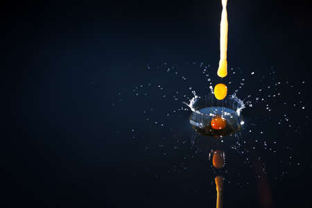 Drops of coffee splashing in water with a blue background, high speedの写真素材