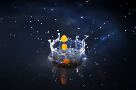 Drops of milk with coffee splashing in water with a blue background, high speedの写真素材