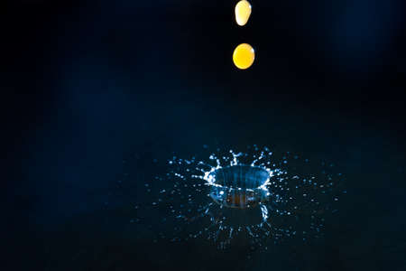 Drops of coffee splashing in water with a blue background, high speedの写真素材