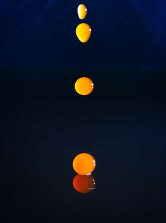 Drops of coffee falling in water with a blue background, high speedの写真素材