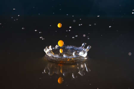 Drops of coffee splashing in water with a dark background, high speedの写真素材