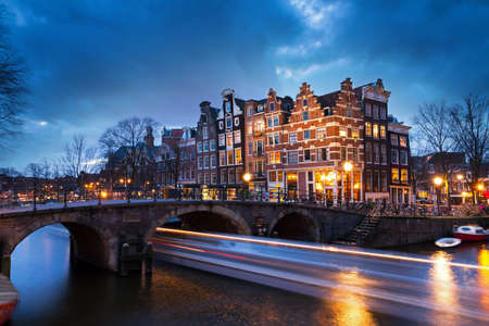 Beautiful view on the Brouwersgracht in Amsterdam, the Netherlands, with a passing canal tour boat after sunsetのeditorial素材
