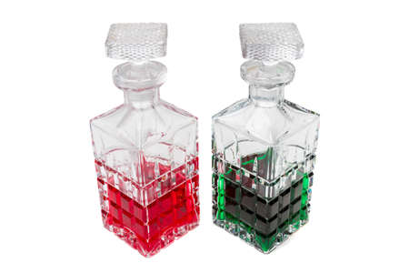 Crystal bottles with liquid in different colors  against a white backgroundの写真素材