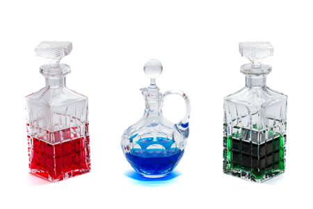 Crystal bottles with liquid in different colors  against a white backgroundの写真素材