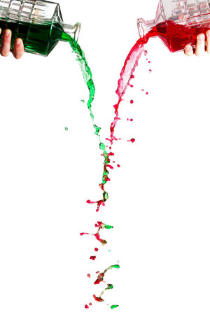 Crystal bottles pouring red and green liquid against a white background