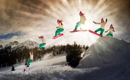 Female snowboarder making an awesome big jump of a kickerの写真素材
