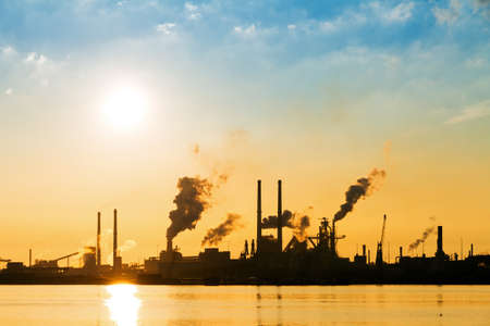 Sunset view of the heavy industry with smoking chimneys in IJmuiden, the Netherlandsの写真素材