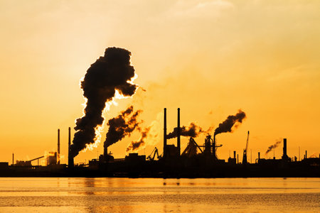 Sunset view of the heavy industry with smoking chimneys in IJmuiden, the Netherlandsの写真素材