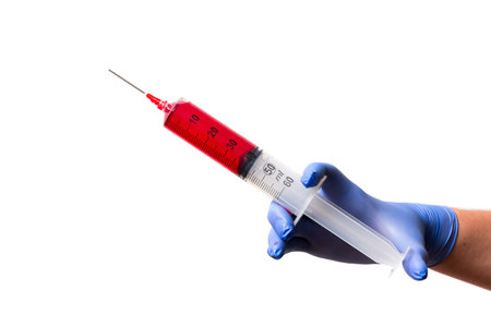 Big syringe with red liquid ready to vaccinate an arm or take bloodの写真素材