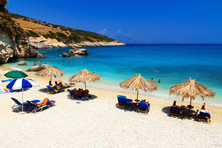 People are relaxing under a straw parasol on the beach at Xigia on the island of Zakynthos in July 2013のeditorial素材