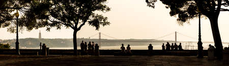 High contrast panoramic image of people looking at the view over Lisbon, Portugal, with in the  25 de Abril Bridge  のeditorial素材