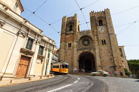 The Lisbon Cathedral with a traditional yellow tram in Lisbon, Portugalのeditorial素材