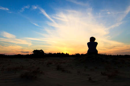 Silhouette of a beautiful woman at sunset in national park Kootwijkerzand in the Netherlandsの写真素材