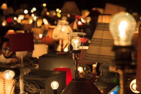 A lot of lamps and bulbs together at night, focussed on one lamp の写真素材
