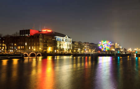 Night view of the river Amstel looking towards theater  Carre  with a piece of art in the river in Amsterdam, The Netherlands, on December 18, 2013の写真素材
