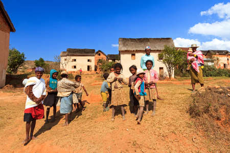 Friendly locals greet the visiting tourists in a typical rural village near Antsirabe in Madagascar on September 5, 2013のeditorial素材