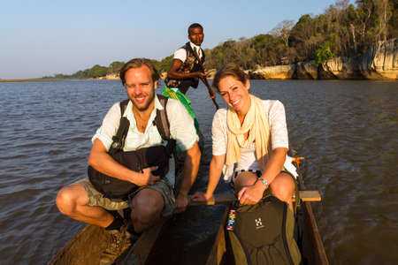 Beautiful tourists take an excursion on the Manambolo river with traditional boats in Belo Tsiribihina, Madagascar, on September 15, 2013のeditorial素材