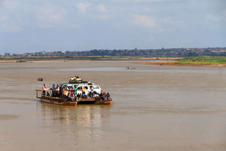 Tourists with their off road vehicle and locals take the ferry during an excursion in Belo Tsiribihina, Madagascar, on September 14, 2013のeditorial素材