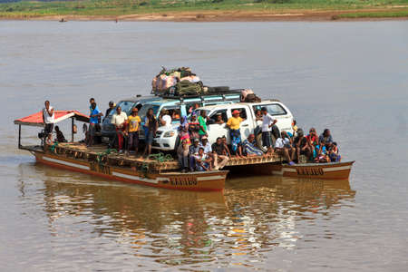 Tourists with their off road vehicle and locals take the ferry during an excursion in Belo Tsiribihina, Madagascar, on September 14, 2013のeditorial素材