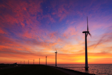 Beautiful sunset at the dike with wind turbines at the Markermeer in the Netherlandsの写真素材