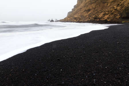 Beautiful winter view of the black sand and rough sea at the beach of Vik in Icelandの写真素材