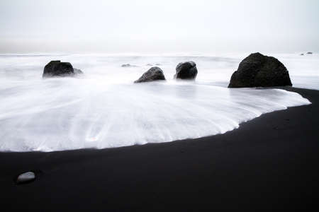 Beautiful winter view of the black sand and rough sea at the beach of Vik in Icelandの写真素材