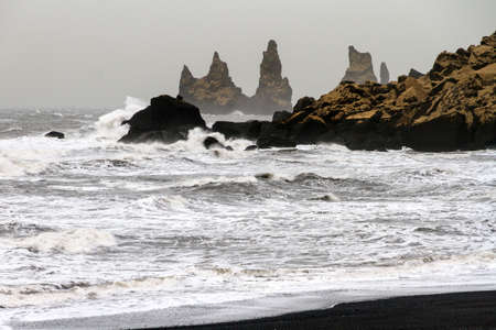 Beautiful winter view of the rocks and rough sea at the black beach of Vik in Icelandの写真素材