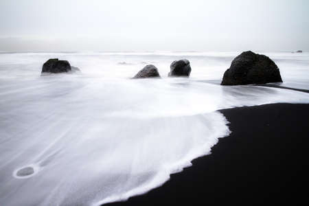 Beautiful winter view of the black sand and rough sea at the beach of Vik in Icelandの写真素材