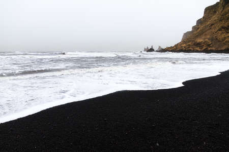 Beautiful winter view of the black sand and rough sea at the beach of Vik in Icelandの写真素材