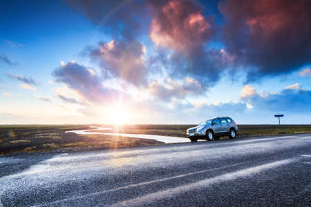 A car on the road at sunrise in the beautiful volcanic landscape of Myrdalssandur in the southern part of Iceland in winterの写真素材