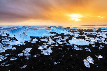 Beautiful beached chunks of ice at the beach at Jokulsarlon, Iceland, at sunset in winterの写真素材