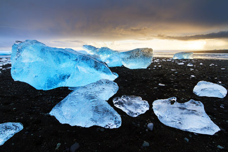 Beautiful beached chunks of ice at the beach at Jokulsarlon, Iceland, at sunset in winter