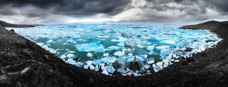 Beautiful 180 degree panoramic view of the floating blue ice in the Jokulsarlon lake in Iceland in...