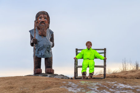 Beautiful international fashion model sits in the chair of a random wooden statue of an Icelandic...