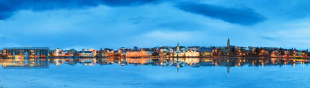 Beautiful panorama of the skyline cityscape of Reykjavik, reflected in lake Tjornin at the blue hour in winterの写真素材