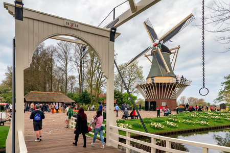 Tourists at the windmill in flower-park the Keukenhof garden of europe, kitchen garden in Lisse, the Netherlands, on april 7, 2014のeditorial素材