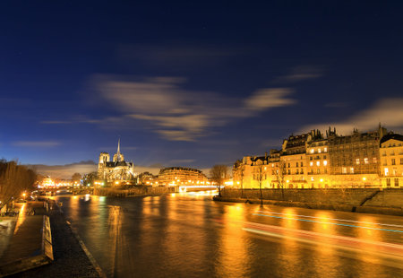 Beautiful view of the river Seine with the Notre-Dame Cathedral in Paris at nightの写真素材