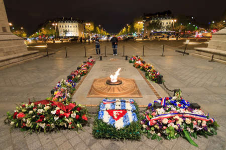 Tourists look at the tomb of the unknown soldier at the Arc the Triomphe at night in Paris, France, on April 13, 2014のeditorial素材