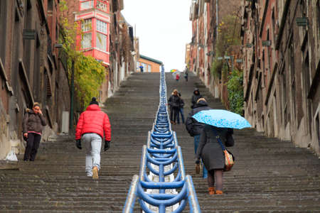 Tourists and local people climbing up the Montagne de Bueren staircase in Liege, Belgium, on a rainy December afternoon in 2014の写真素材