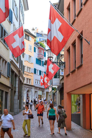 Vibrant view of the stores and flags in the shopping center at the Strehlgasse in Zurich, Switzerland, with people in the street at day timeのeditorial素材