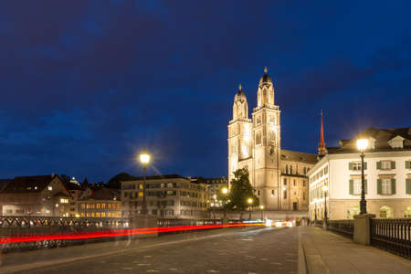 Beautiful cityscape of Zurich, Switzerland, with the Grossmünster Protestant church, seen from the shore of the river Limmat at night in summerのeditorial素材