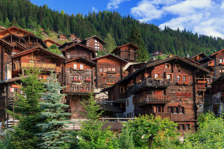 Beautiful cityscape of the alpine village Grimentz, Switzerland, with traditional wooden houses in summerの写真素材