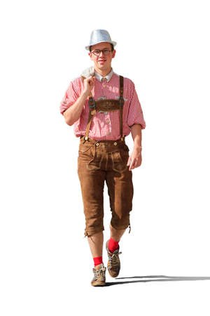 Handsome young man in traditional clothing with lederhosen and checkered shirt in summer,  isolated on a white backgroundの写真素材