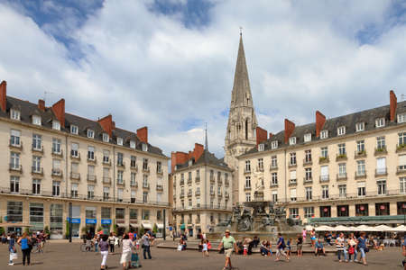 People visiting town square Place Royale in the shopping center of Nantes, France, on a summer day with the Basilique Saint-Nicolas de Nantes in the background, on July 29, 2014のeditorial素材
