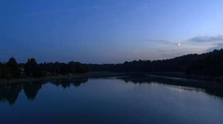 Beautiful dark blue nightscape landscape of the coastal river L'Arguenon after sunset with a new moon rising and reflection in the water near Saint-Malo in Brittany, Franceの写真素材